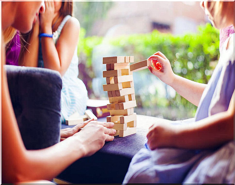 Family playing Jenga, one of the board games to improve attention.