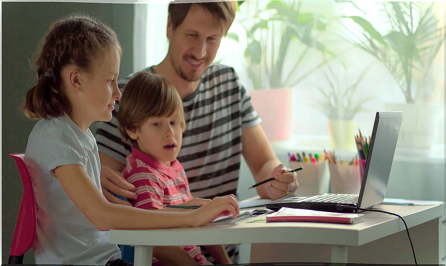 Father helping his children to study at home.