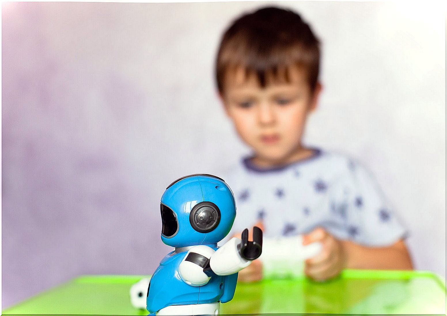 Boy playing with a robot with artificial intelligence.