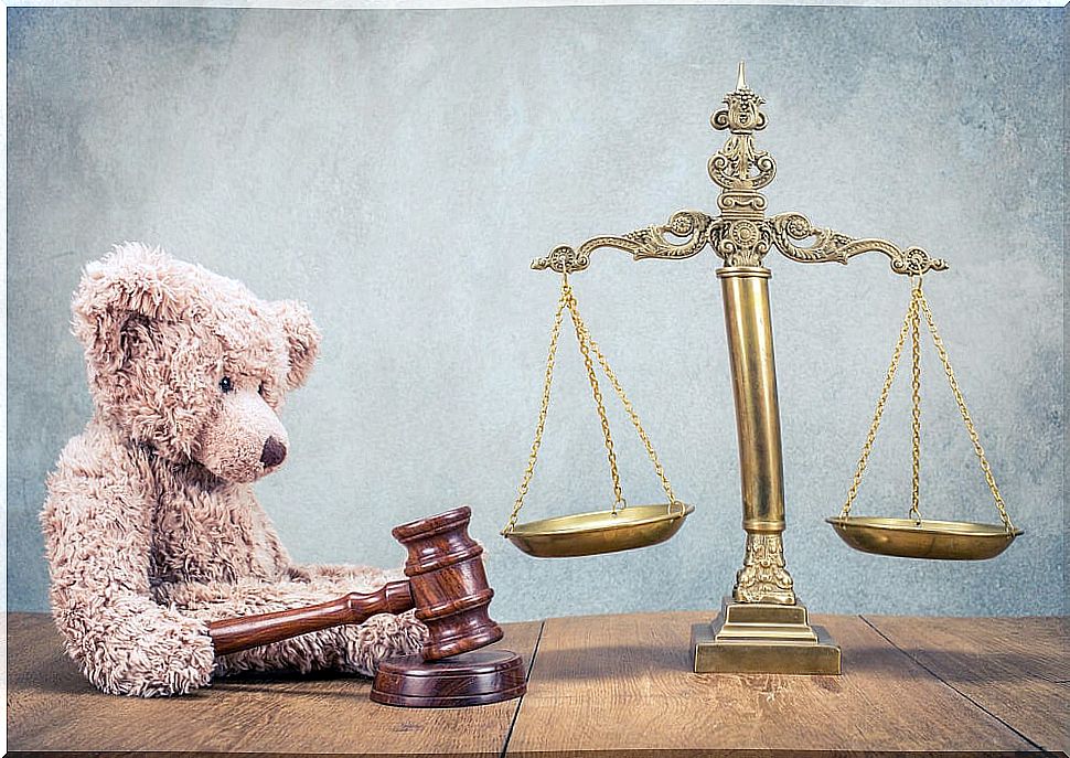 Teddy bear and scales of justice to represent family trials.