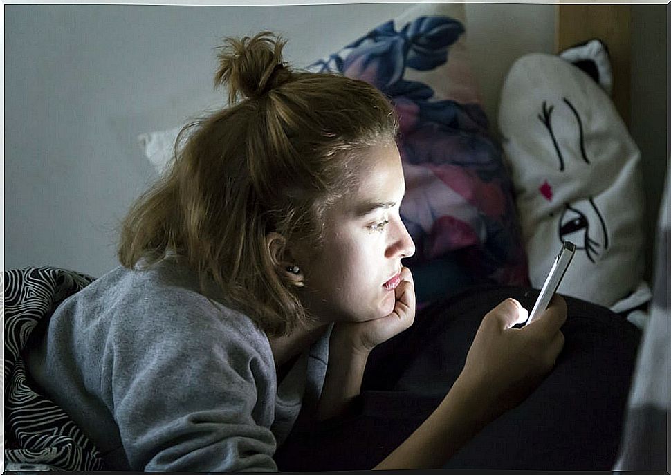 Teenager consulting his social networks on his mobile.