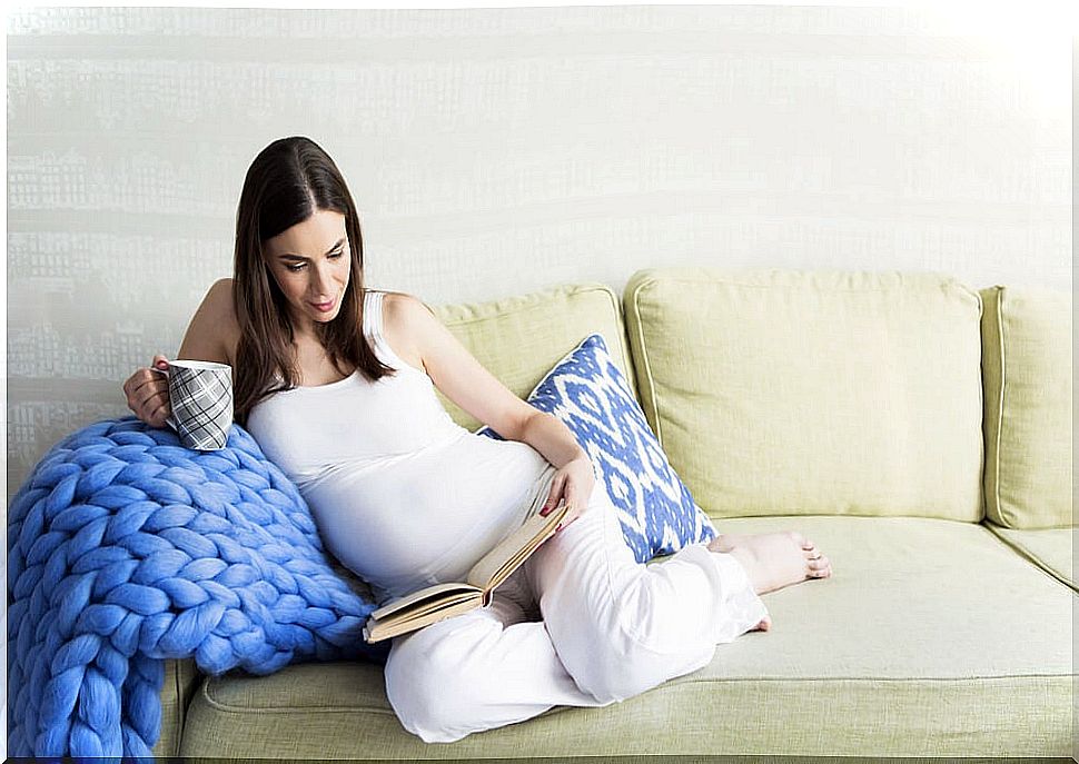 Pregnant woman reading one of the books on motherhood that we present in this article.