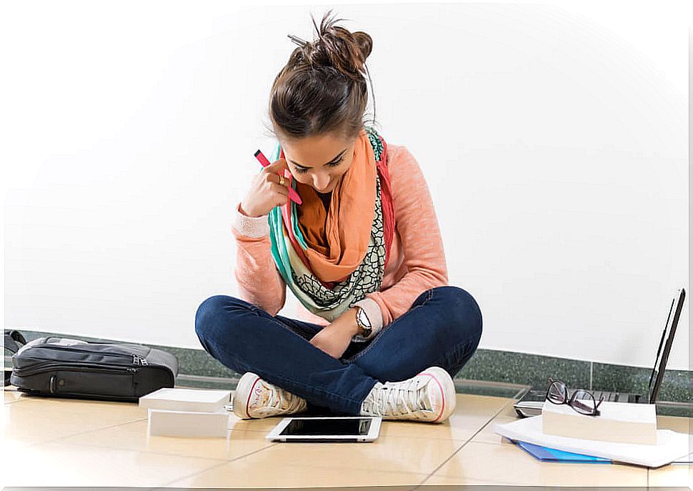 Girl reviewing for an exam sitting in the middle of the hall.