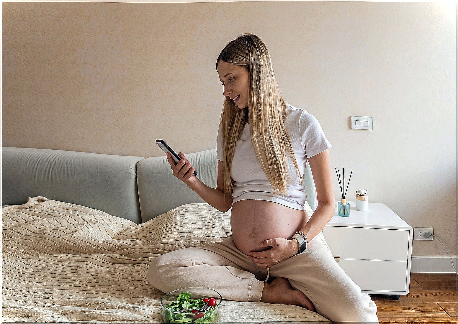 Pregnant woman looking at one of the Instagram accounts that you should follow if you are pregnant.