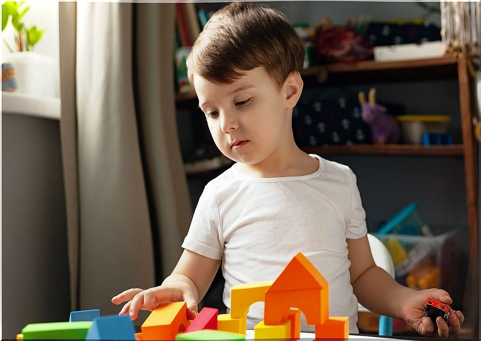 Child playing with the building blocks but not wanting to pick them up.