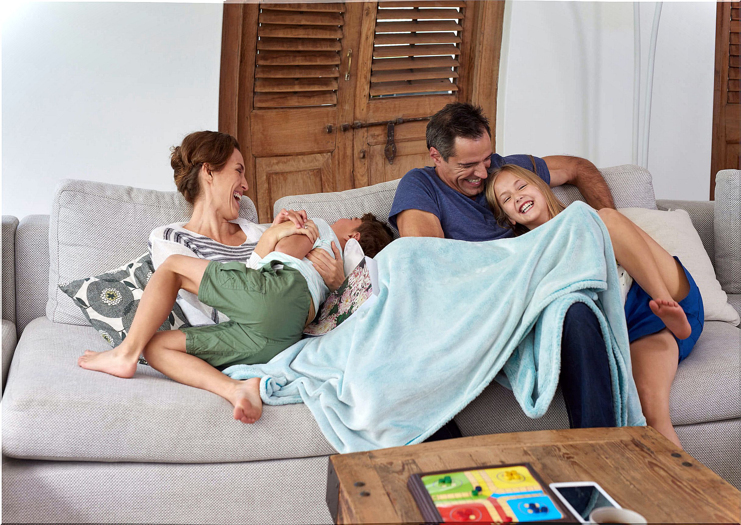 Parents hugging their children while laughing as a family.