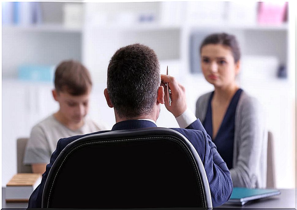 Mother with her son in a meeting with his teacher to claim a grade that they consider unfair.