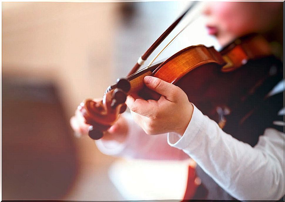 Boy playing the violin in art education class.