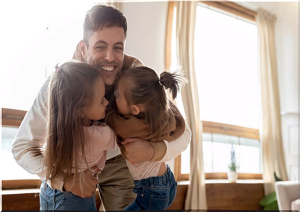 Father hugging his daughters after reflecting on their anger.