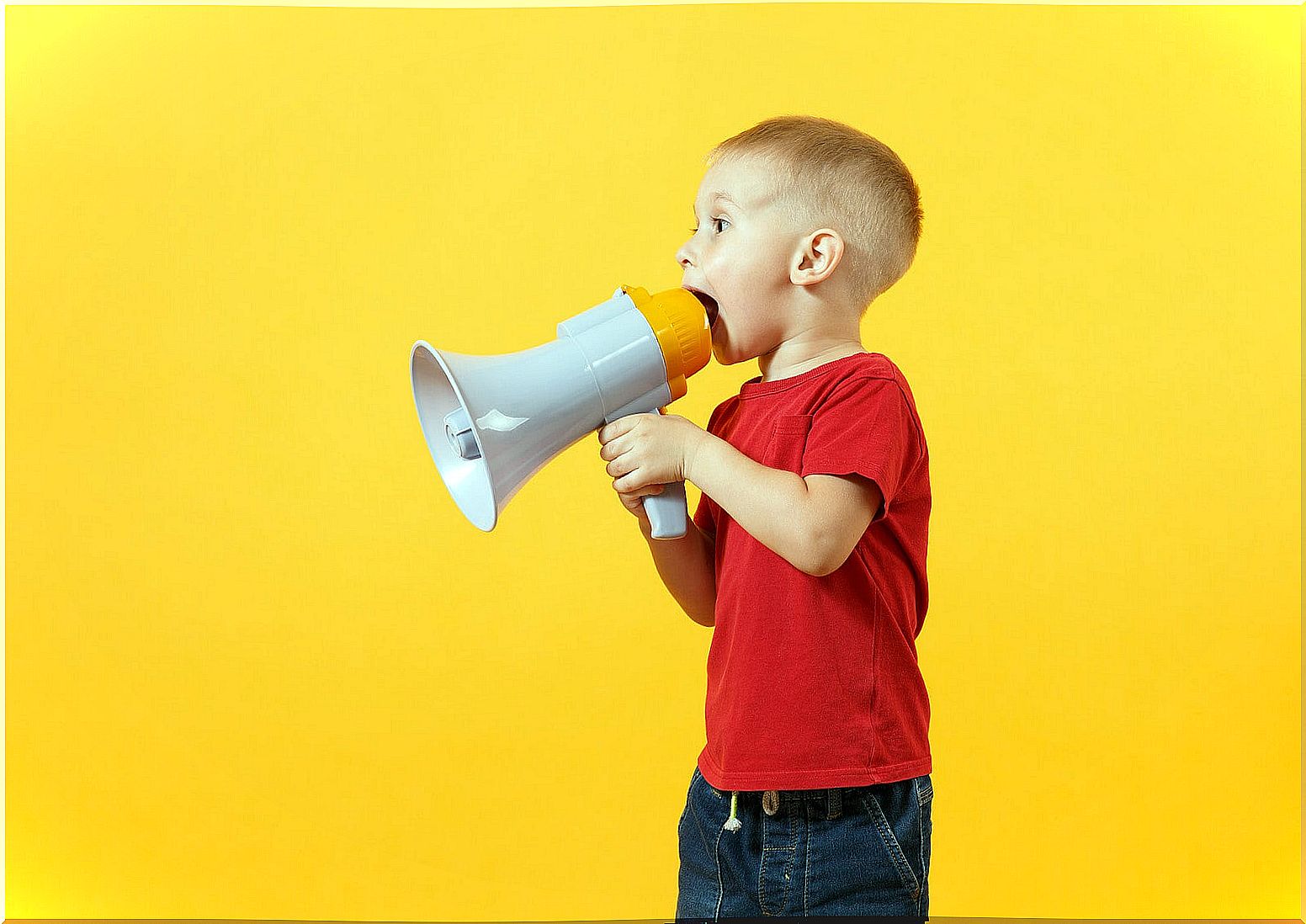 Child speaking with a megaphone for language development between 1-2 years.