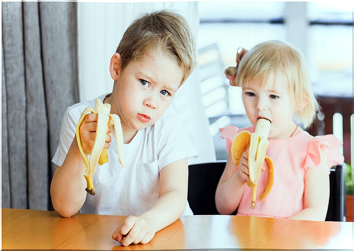 Children eating one banana each.