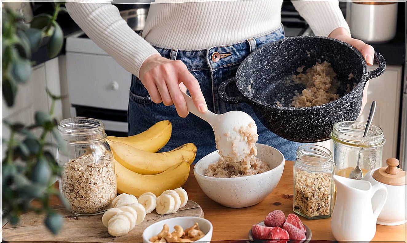 Woman preparing an oatmeal and fruit porridge during the first trimester of pregnancy.