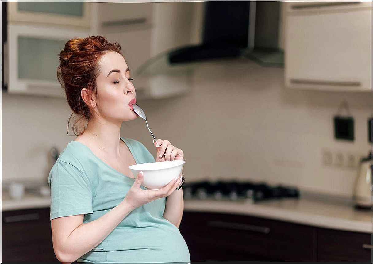 Pregnant woman enjoying while eating during the third trimester of pregnancy.