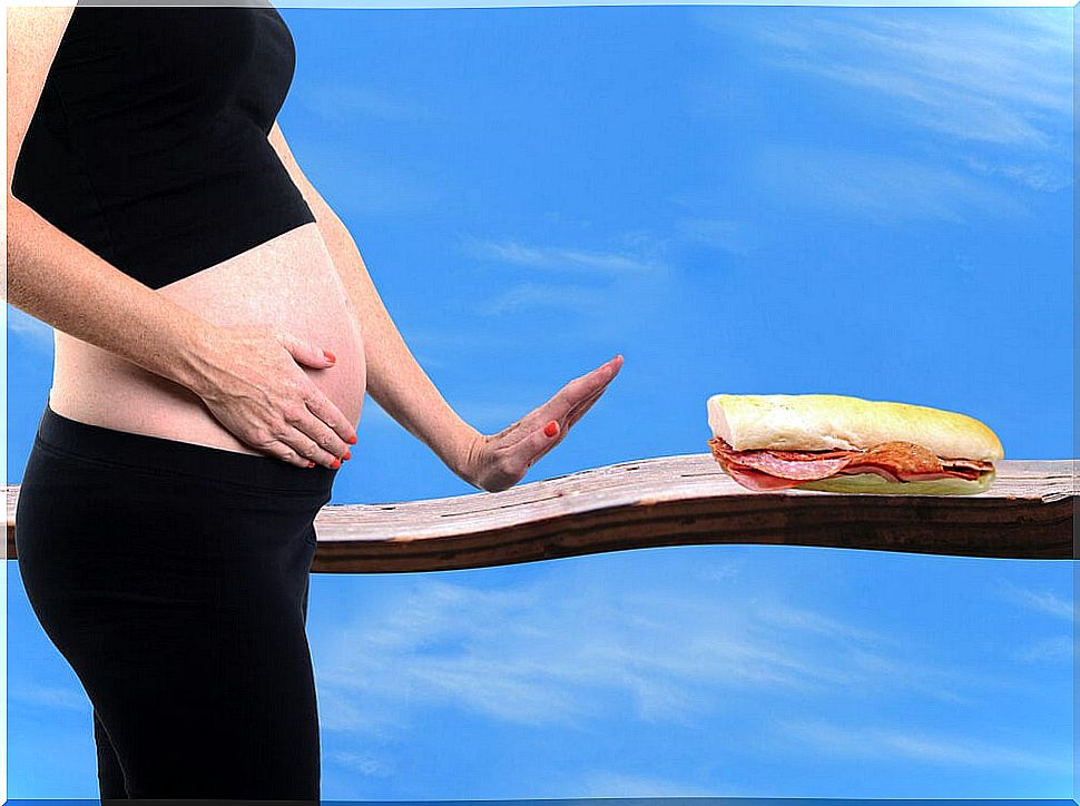 Pregnant woman refusing a snack to avoid neonatal listeriosis.