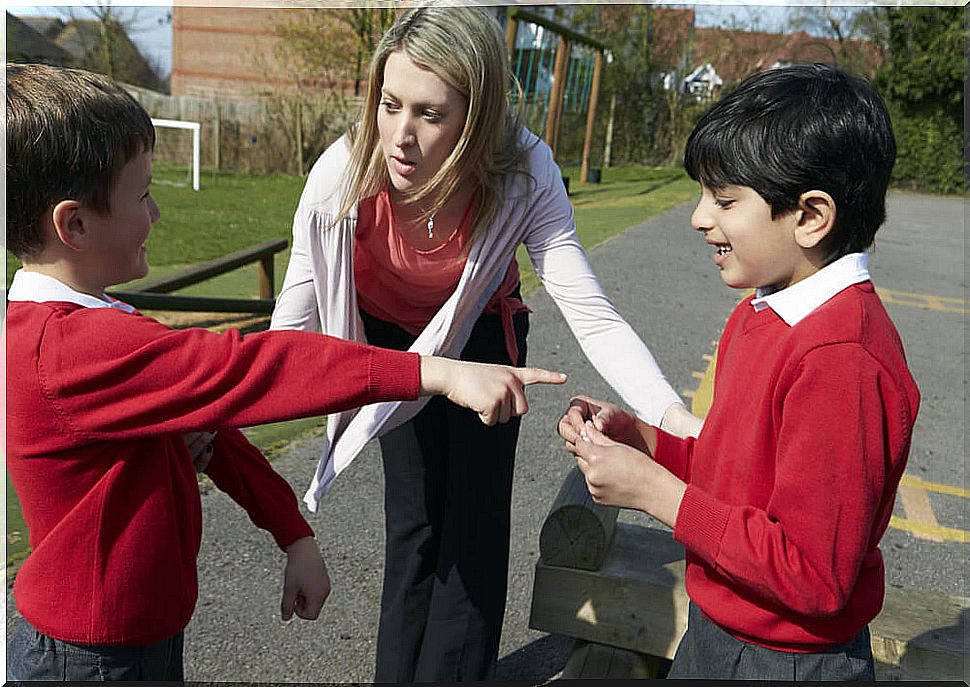 Teacher acting to prevent bullying in a fight between two students.