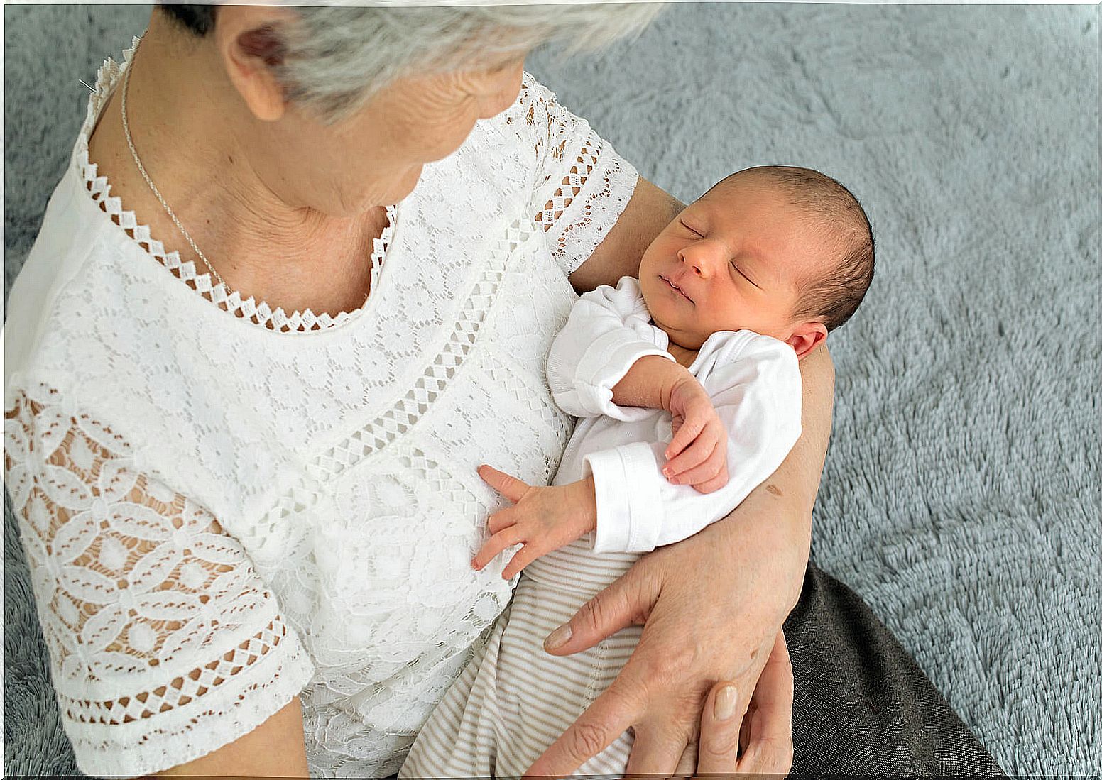 Grandmother with her newborn grandson in her arms.