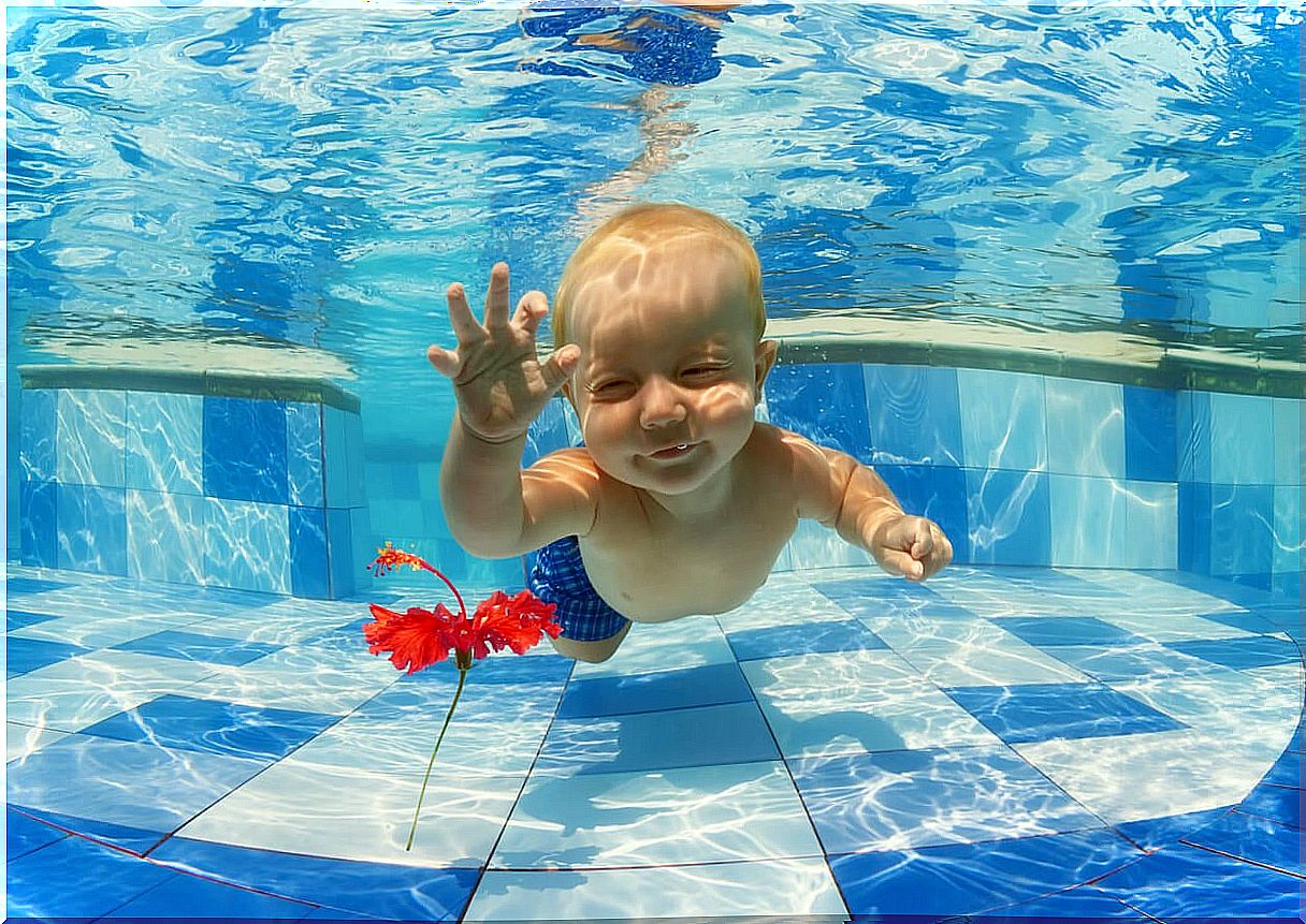 Baby practicing swimming, one of the appropriate sports according to his age.